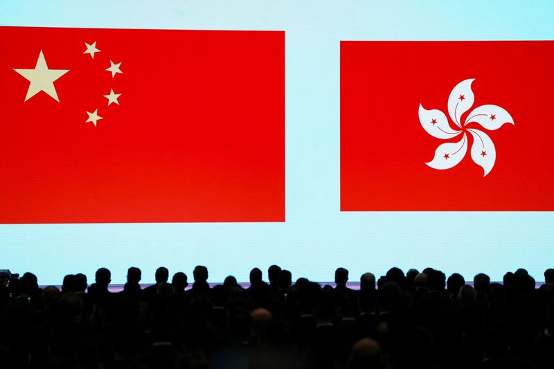 &copy; Reuters. People stand in front of a screen showing the Chinese and the Hong Kong flags during the National Security Education Day opening ceremony in Hong Kong, China April 15, 2024. REUTERS/Lam Yik