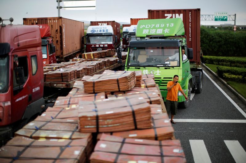 © Reuters. FILE PHOTO: Trucks carrying copper and other goods are seen waiting to enter an area of the Shanghai Free Trade Zone, in Shanghai September 24, 2014. REUTERS/Carlos Barria/File Photo