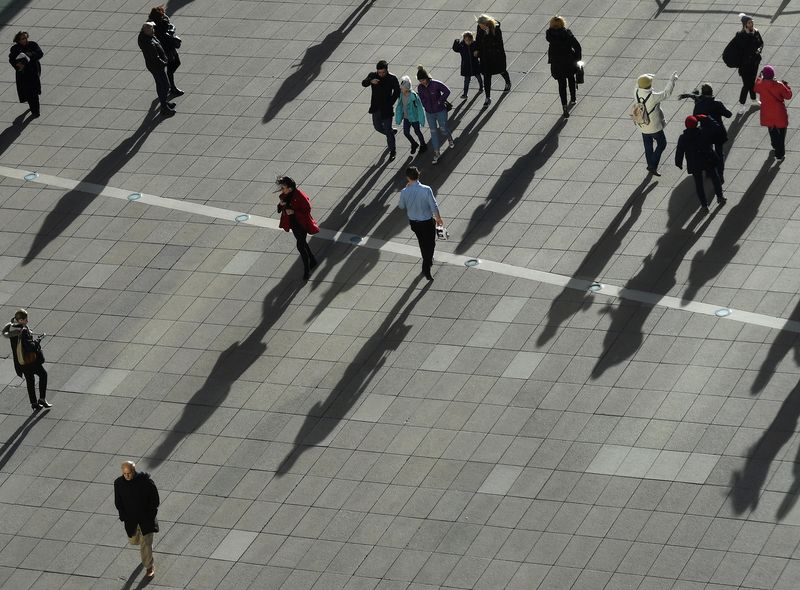 &copy; Reuters. FILE PHOTO: People cast long shadows in the winter sunlight as they walk across a plaza in the Canary Wharf financial district of London, Britain, January 17, 2018. REUTERS/Dylan Martinez/File Photo