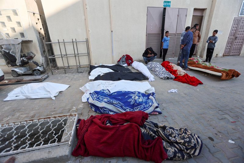 &copy; Reuters. أشخاص إلى جوار جثامين فلسطييين قتلوا في غارات إسرائيلية على مستشفى الأقصى في دير البلح وسط قطاع غزة يوم 14 أبريل نيسان 2024. تصوير: رمضان عبيد - 