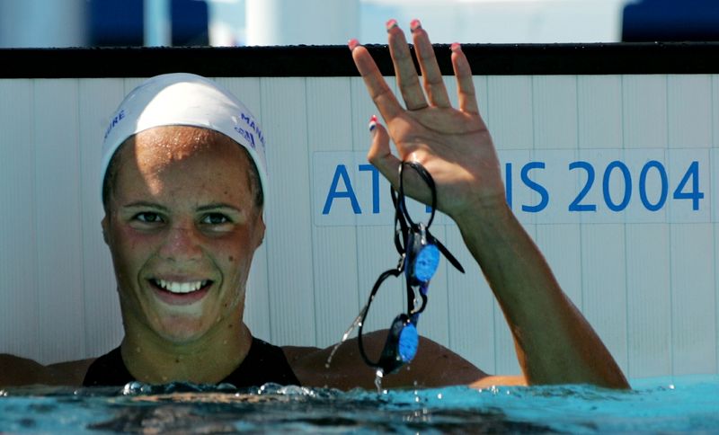 &copy; Reuters. Laure Manaudou salue après avoir nagé dans sa série du 800 mètres nage libre féminin aux Jeux Olympiques d'Athènes 2004. /Photo prise le 19 août 2004/REUTERS/David Gray