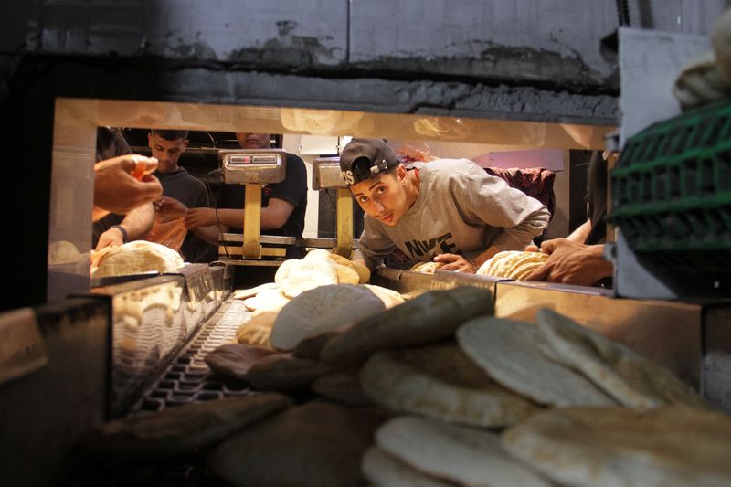 &copy; Reuters. Palestinians make bread at a bakery which went back into service after being shut down for several months due to the lack of flour and energy, amid the ongoing conflict between Israel and Hamas, in Gaza City, April 14, 2024. REUTERS/Mahmoud Issa/File Phot