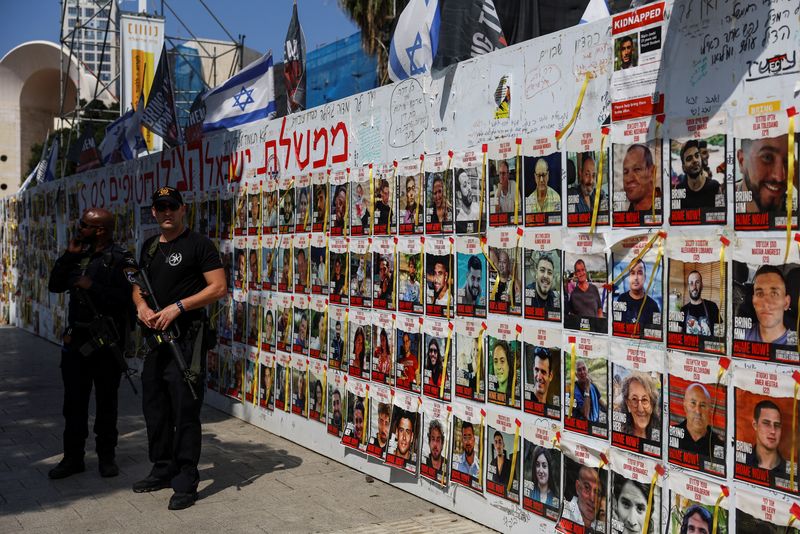 &copy; Reuters. ضباطا شرطة يقفان بجوار ملصقات لصور المحتجزين لدى حركة المقاومة الإسلامية (حماس) في تل أبيب يوم 15 أبريل نيسان 2024. تصوير: هانا مكاي - رويترز
