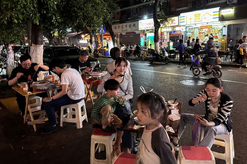 &copy; Reuters. People dine near a restaurant by a street in Chengdu, Sichuan province, China April 12, 2024. REUTERS/Tingshu Wang
