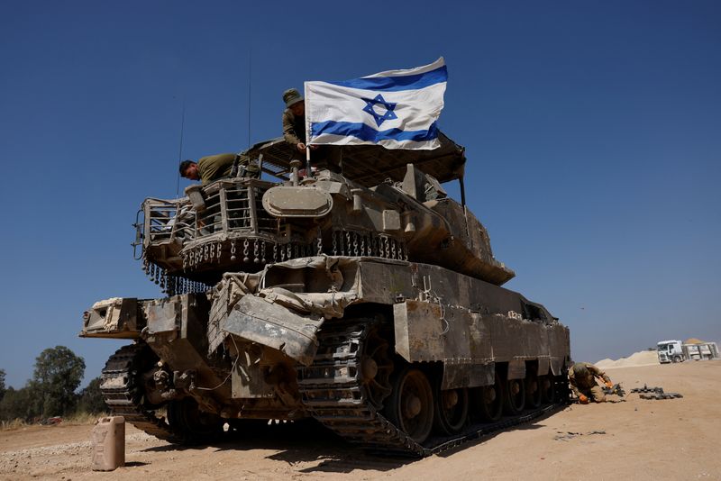 &copy; Reuters. FILE PHOTO: Israeli soldiers mount an Israeli flag on a military vehicle near the Israel-Gaza border, amid the ongoing conflict between Israel and the Palestinian Islamist group Hamas, in Israel, April 15, 2024. REUTERS/Amir Cohen/File Photo