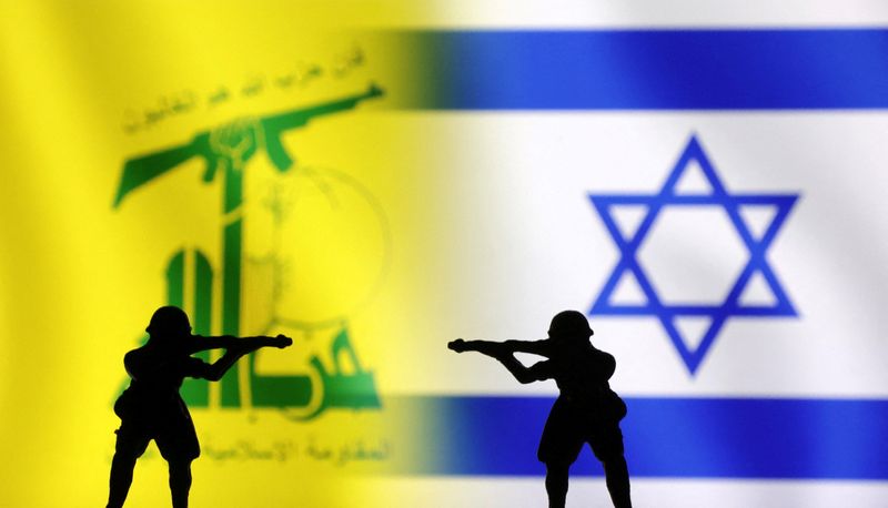 &copy; Reuters. علما إسرائيل وحزب الله أمامها مجسمان لجنديين يصوبان البنادق على بعضهما البعض في صورة توضيحية التقطت يوم 15 أكتوبر تشرين الأول 2023. تصوير: دادو