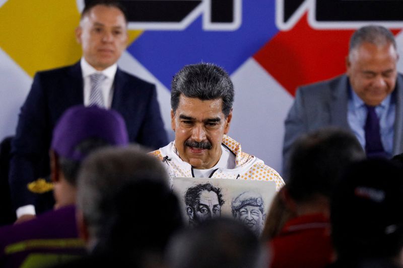 &copy; Reuters. FOTO DE ARCHIVO: El presidente de Venezuela, Nicolás Maduro, sostiene una pancarta con imágenes de Simón Bolívar y Hugo Chávez mientras asiste a registrarse como candidato en las próximas elecciones presidenciales para asegurar otro mandato de seis 