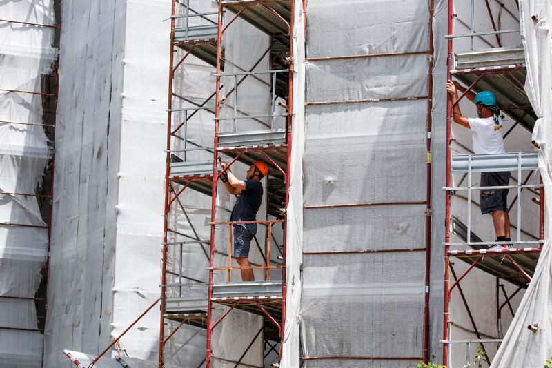 ©Reuters.  Gli operai edili Pierluigi Fusco lavorano sul posto costruendo edifici efficienti dal punto di vista energetico, rendendo gli appartamenti più efficienti dal punto di vista energetico sotto il governo 