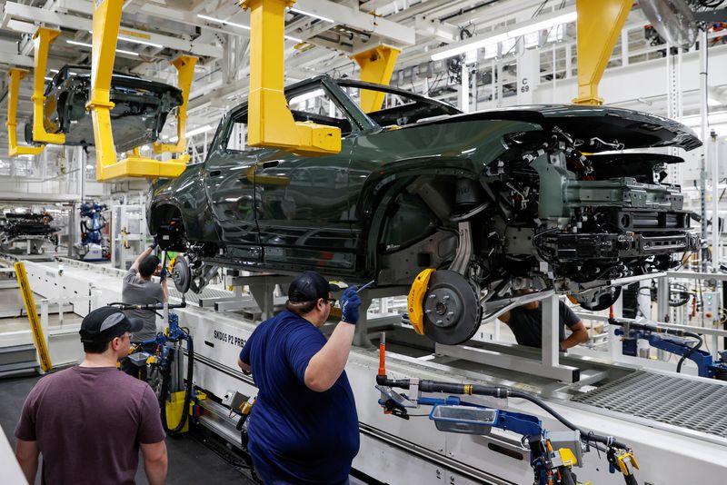 &copy; Reuters. FILE PHOTO: Employees works on an assembly line at startup Rivian Automotive's electric vehicle factory in Normal, Illinois, U.S. April 11, 2022. Picture taken April 11, 2022.  REUTERS/Kamil Krzaczynski/File Photo