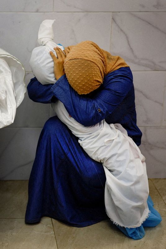 &copy; Reuters. La palestinese Inas Abu Maamar, 36 anni, abbraccia il corpo di sua nipote Saly, di 5 anni, uccisa in un attacco israeliano, all'ospedale Nasser di Khan Younis, nel sud della Striscia di Gaza, il 17 ottobre 2023. Il fotografo di Reuters Mohammad Salem si t