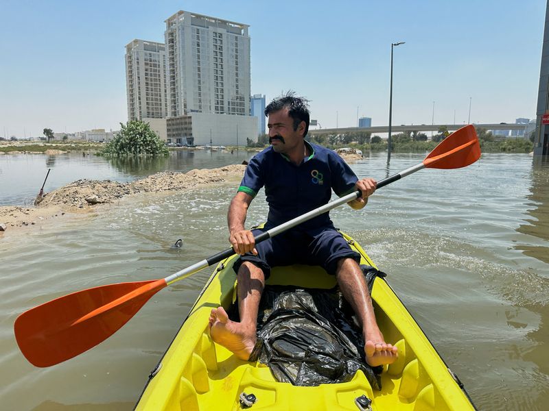 © Reuters. A volunteer uses a kayak during a rescue operation through a road flooded due to heavy rains in Dubai, United Arab Emirates, April 18, 2024. REUTERS/Abdel Hadi Ramahi