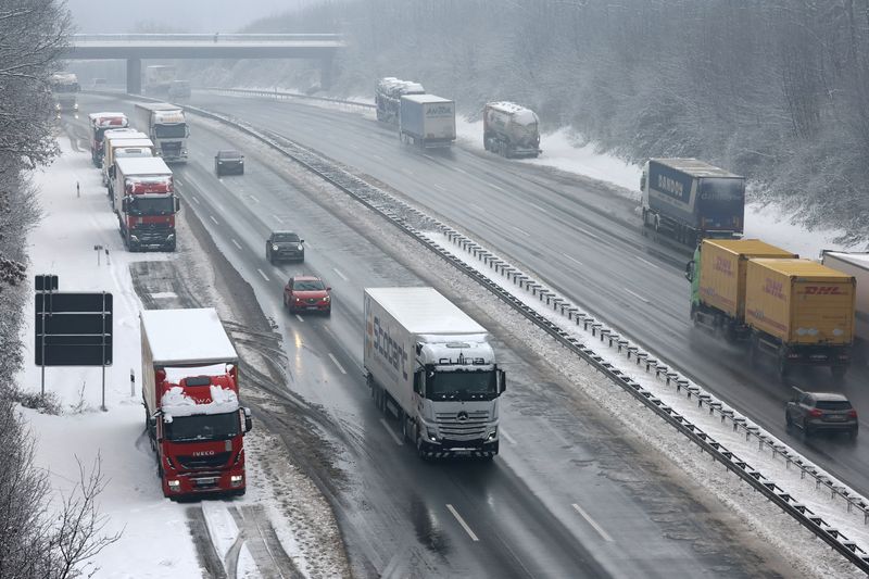 &copy; Reuters. FILE PHOTO: Vehicles pass trucks, parked at the emergency lane after heavy snowfall at the A3 highway, near Aegidinberg, Germany, January 18, 2024.     REUTERS/Wolfgang Rattay/File Photo