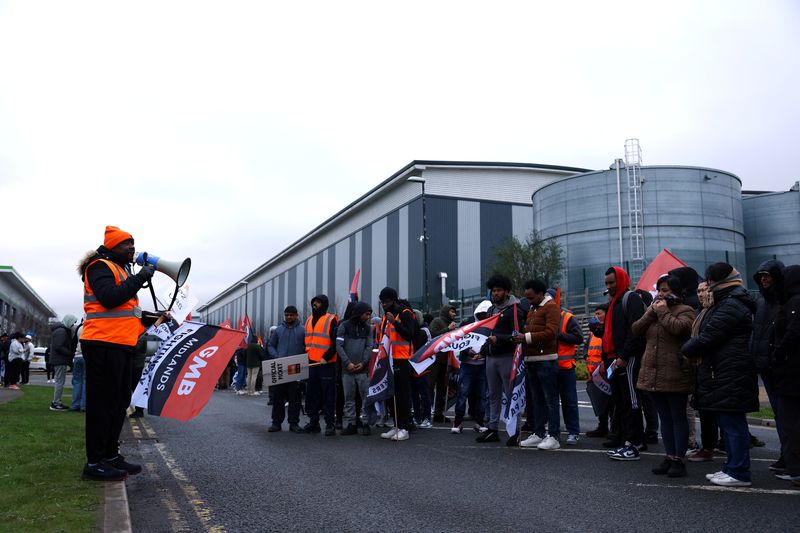 © Reuters. FILE PHOTO: Protestors hold placards during industrial action outside the Amazon warehouse, in Coventry, Britain March 19, 2024. REUTERS/Molly Darlington/File Photo
