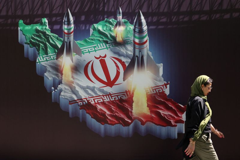 &copy; Reuters. امرأة إيرانية تسير أمام لافتة مناهضة لإسرائيل عليها صورة صواريخ إيرانية في أحد شوارع طهران يوم 19 أبريل نيسان 2024. صورة لرويترز من وكالة غرب آ