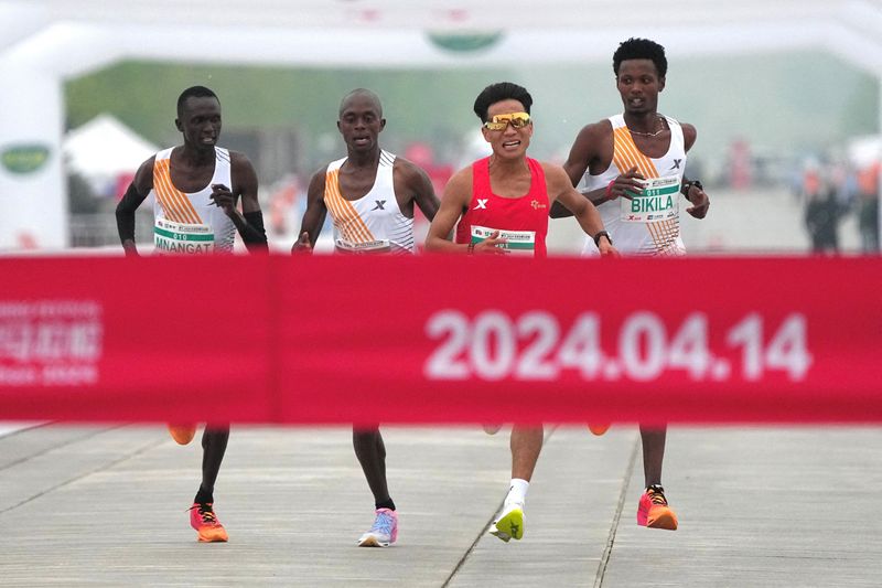 &copy; Reuters. Foto de archivo del atleta chino He Jie, el etiope Dejene Hailu Bikila y los kenianos Robert Keter y Willy Mnangat en el final del Maratón de Pekín 
April 14, 2024. cnsphoto via REUTERS/
