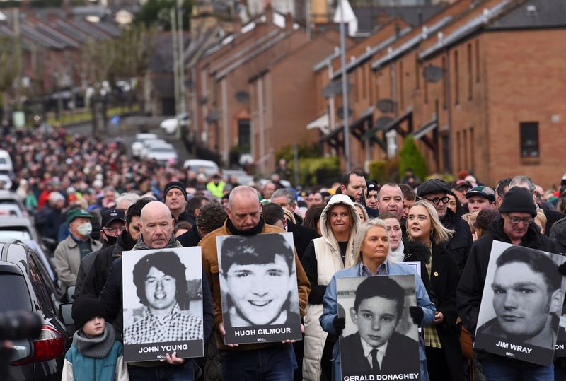 &copy; Reuters. People hold pictures of the victims of 'Bloody Sunday' as they retrace the steps of the original 1972 civil rights march, in a walk of remembrance to mark the 50th anniversary of 'Bloody Sunday', in Londonderry, Northern Ireland, January 30, 2022. REUTERS