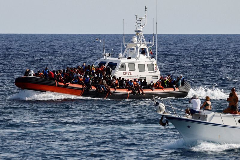 &copy; Reuters. FILE PHOTO: An Italian Coast Guard vessel carrying migrants rescued at sea passes near a tourist boat, on the Sicilian island of Lampedusa, Italy, September 18, 2023. REUTERS/Yara Nardi//File Photo