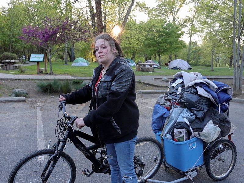 © Reuters. Amber Rockwell makes a final ride by bicycle to switch her property to a particular camp to assign some distance from being ticketed by police, in Grants Traipse, Oregon, U.S., April 17, 2024.  REUTERS/Deborah Bloom