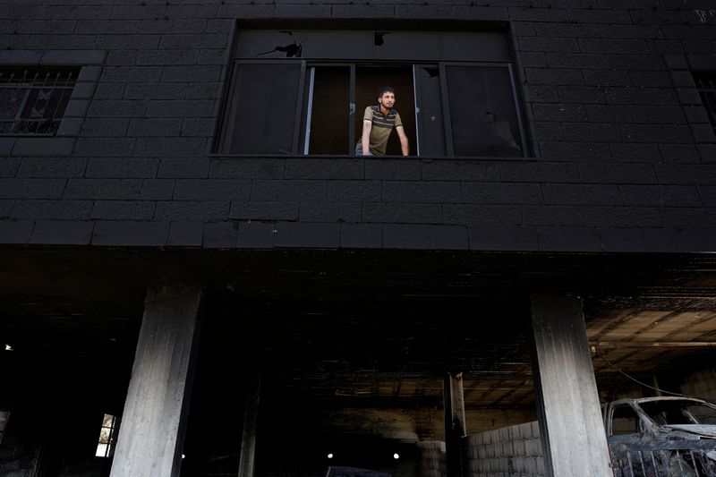 &copy; Reuters. رجل ينظر من نافذة منزل تعرض لأضرار بعد هجوم مستوطنين إسرائيليين على قرية المغير في الضفة الغربية التي تحتلها إسرائيل يوم 17 أبريل نيسان 2024. ت