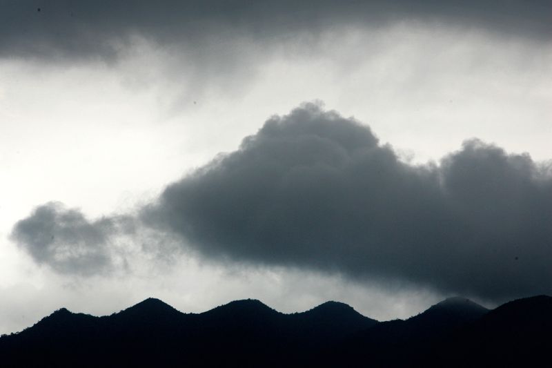 &copy; Reuters. FOTO DE ARCHIVO: Nubes oscuras se ciernen sobre las montañas de Zhaoqing, en la provincia meridional de Cantón, China. 27 de junio de 2005. REUTERS/Jason Lee/Archivo