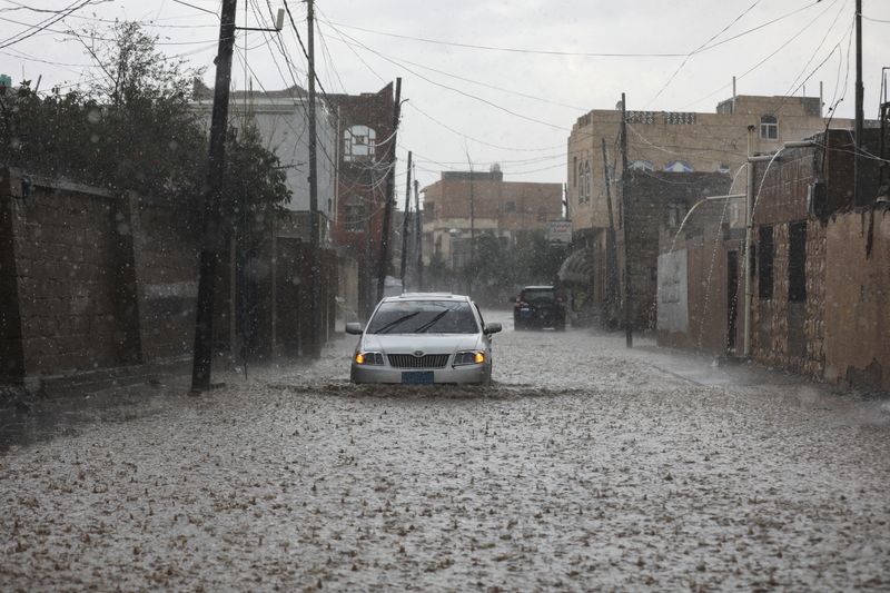 &copy; Reuters. سيارة تشق طريقها في طريق تغمره المياء في صنعاء يوم 20 أبريل نيسان 2024. تصوير: خالد عبد الله - رويترز