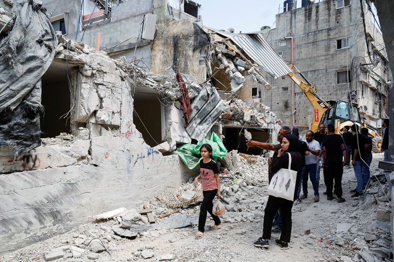 © Reuters. فلسطينيون يتفقدون الأضرار التي لحقت بمبنى في أعقاب غارة إسرائيلية في مخيم نور شمس بطولكرم في الضفة الغربية المحتلة يوم 21 أبريل نيسان 2024. تصوير: رنين صوافطة - رويترز