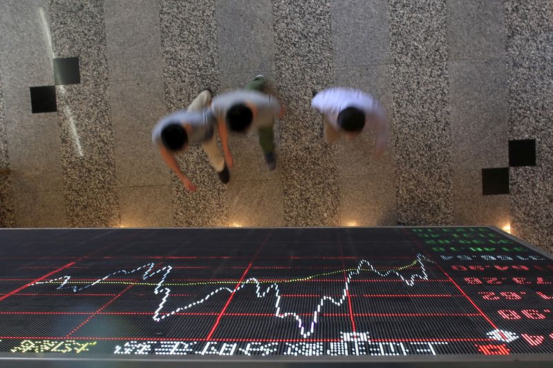 © Reuters. FILE PHOTO: People walk under an electronic board showing stock information at the Shanghai Stock Exchange in Lujiazui Financial Area in Shanghai, China, September 22, 2015. REUTERS/Aly Song/File Photo