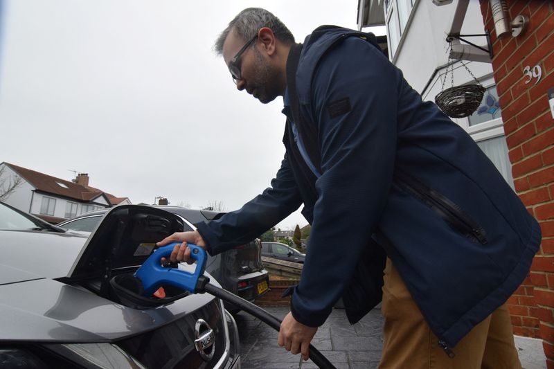 © Reuters. FILE PHOTO: Shilpen Patel plugs in his bidirectional electric Nissan Leaf, which is able to power his home and provide power back to the grid, at his house in London, Britain, February 20, 2024. REUTERS/Nick Carey/File Photo