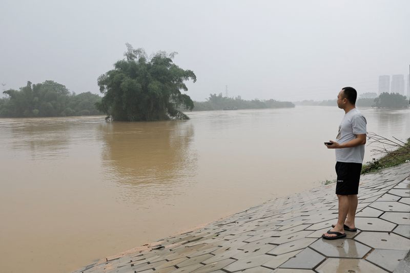 &copy; Reuters. Photo d'un habitant près d'une rivière en crue suite à de fortes pluies à Qingyuan. /Photo prise le 22 avril 2024 à Qingyuan, Chine/REUTERS/Tingshu Wang