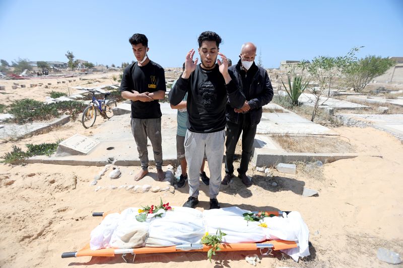 &copy; Reuters. أشخاص يؤدون صلاة الجنازة بعد إعادة دفن جثامين فلسطينيين قتلوا خلال الهجوم العسكري الإسرائيلي في خان يونس بجنوب قطاع غزة يوم 21 أبريل نيسان 202