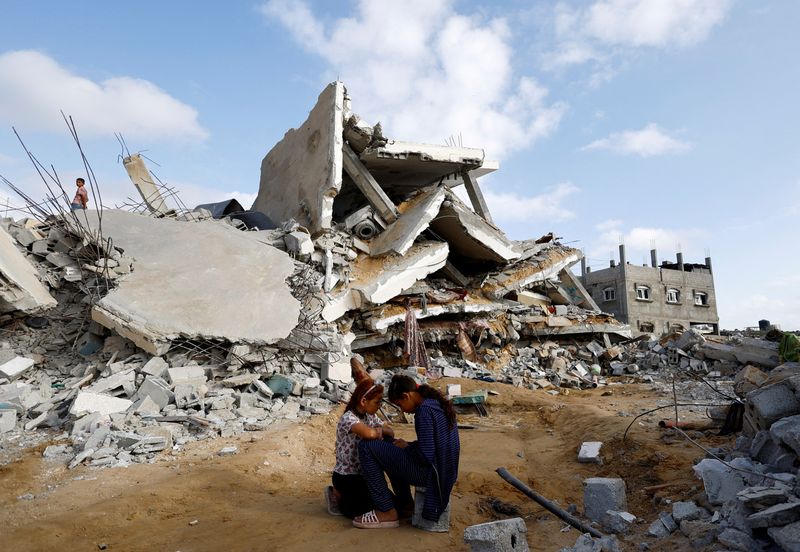&copy; Reuters. Niños palestinos frente a un edifico destruido por los ataques israelíes en Rafah, Franja de Gaza. 21 abril 2024. REUTERS/Mohammed Salem