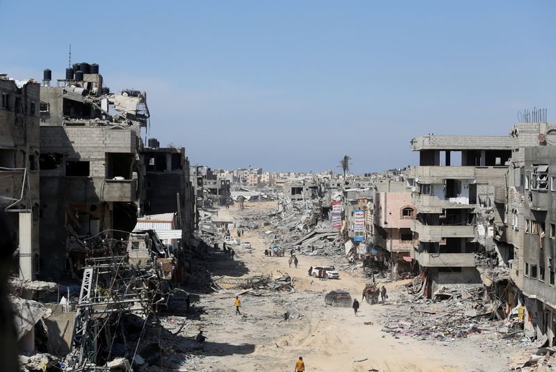 &copy; Reuters. Palestinesi ispezionano edifici residenziali distrutti a Khan Younis, nel sud della Striscia di Gaza, 7 Aprile 2024. REUTERS/Ahmed Zakot/File Photo