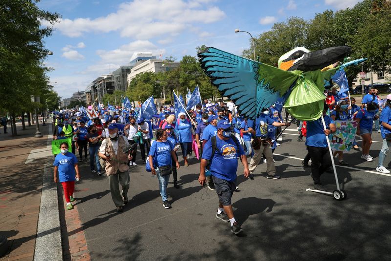 &copy; Reuters. FILE PHOTO: People march along Constitution Avenue during a rally with migrant families and immigration advocates calling for a pathway towards citizenship, near Capitol Hill in Washington, U.S., September 20, 2021.  REUTERS/Tom Brenner/File Photo