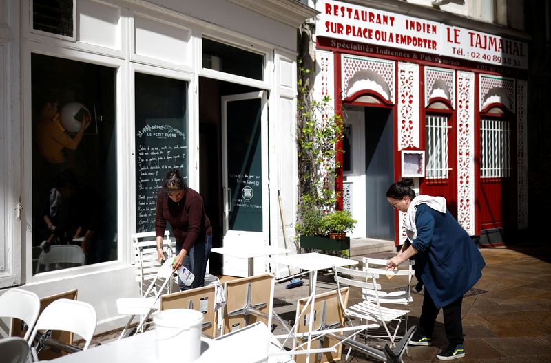 &copy; Reuters. Dipendenti puliscono tavoli e sedie durante i preparativi per la riapertura di ristoranti e bar a Nantes, nell'ambito dell'allentamento delle restrizioni di chiusura del Paese a causa dell'epidemia di coronavirus (Covid-19) in Francia, 17 maggio 2021. REU
