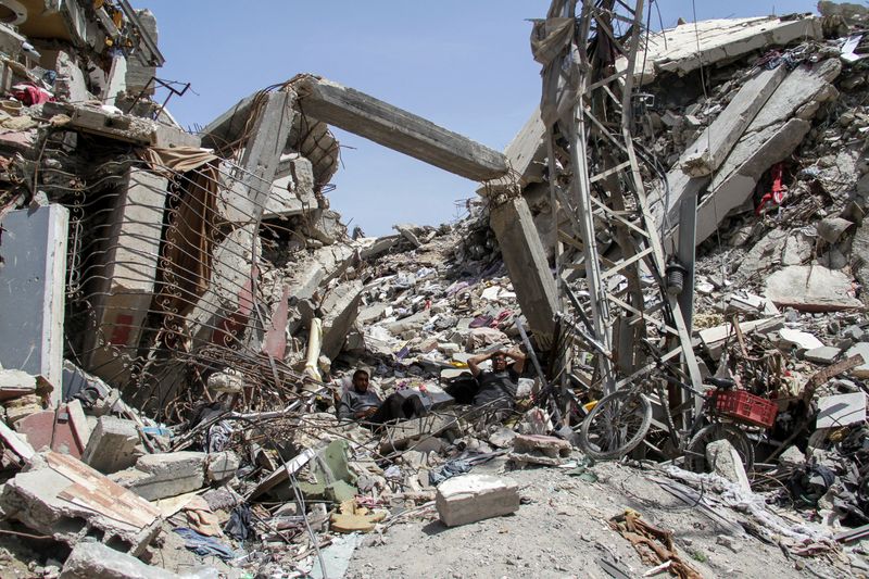 &copy; Reuters. Des Palestiniens se reposent sur les décombres d'un immeuble résidentiel détruit par des frappes israéliennes, dans le cadre du conflit entre Israël et le Hamas, dans le nord de la bande de Gaza. /Photo prise le 22 avril 2024/REUTERS/Mahmoud Issa    
