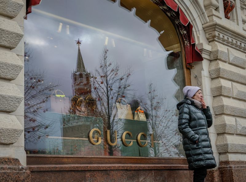 &copy; Reuters. A woman smokes in front of a closed Gucci store in the the State Department Store, GUM, in central Moscow, Russia February 14, 2023. REUTERS/Shamil Zhumatov/ File photo