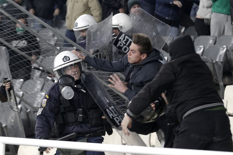 © Reuters. مشجعو كرة القدم يشتبكون مع أفراد من شرطة مكافحة الشغب خلال إحدى المباريات في الدوري اليوناني في صورة من أرشيف رويترز 