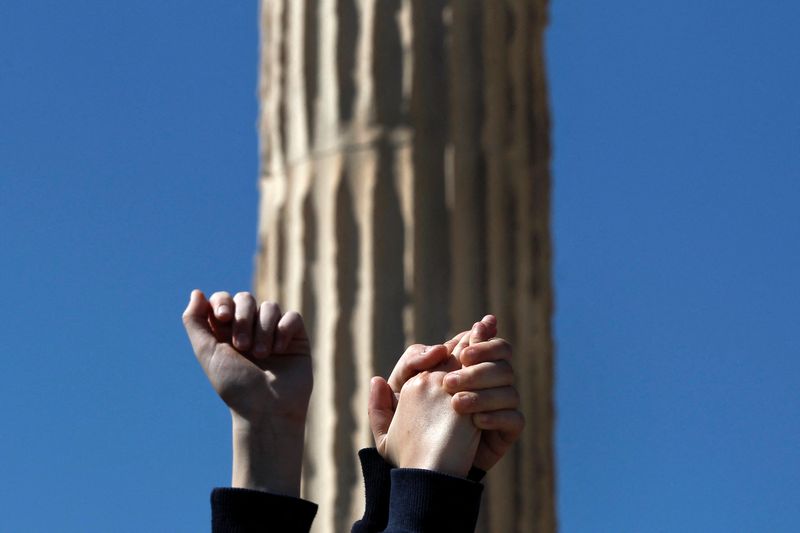 &copy; Reuters. FOTO DE ARCHIVO. Niños levantan la mano frente a una columna del templo Erecteion en la colina de la Acrópolis durante una protesta simbólica contra el racismo, en Atenas, Grecia, el 21 de marzo de 2014. REUTERS/Alkis Konstantinidis