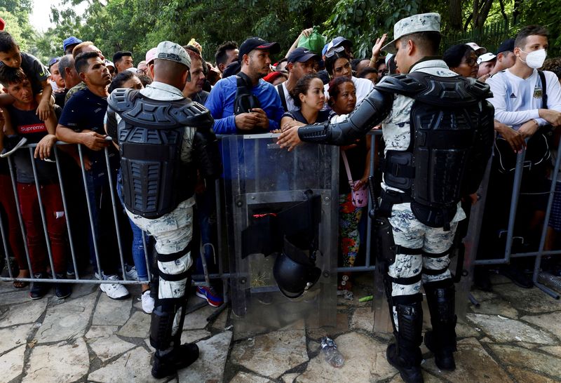 &copy; Reuters. FOTO DE ARCHIVO. Agentes encargados de hacer cumplir la ley vigilan mientras los migrantes se reúnen frente a una oficina de la Comisión de Ayuda a Refugiados de México para obtener una visa humanitaria que les permita un paso seguro para continuar su 