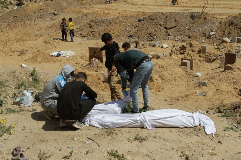 &copy; Reuters. فلسطينيون يغطون أحد الجثامين التي وجدت مدفونة في مقبرة جماعية شمالي قطاع غزة يوم 15 أبريل نيسان 2024. تصوير: محمد عيسى - رويترز 