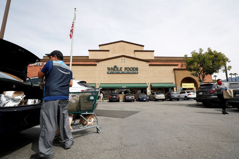&copy; Reuters. FILE PHOTO: An Amazon shopper and courier loads groceries into his trunk outside a Whole Foods Market grocery store in Pasadena, California, U.S., March 31, 2020. REUTERS/Mario Anzuoni/File Photo
