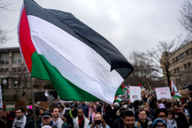 &copy; Reuters. FILE PHOTO: A Palestinian flag flies over a group of pro-Palestinian demonstrators as they march outside the Israeli embassy to call for a ceasefire in Gaza, amid the ongoing conflict between Israel and the Palestinian Islamist group Hamas, during a prote