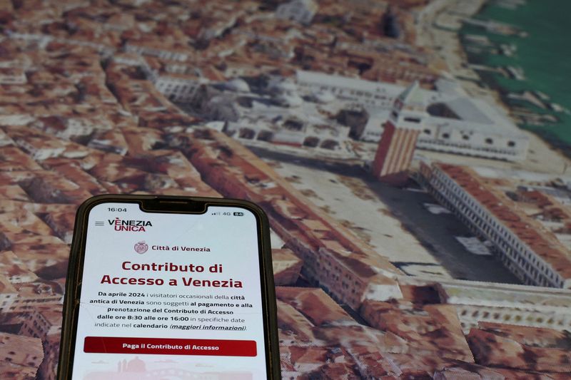 &copy; Reuters. FILE PHOTO: A web app to pay the entrance fee for Venice is seen on a mobile phone in this illustration picture taken in the control room where monitors are used to check the number of tourists entering and leaving the city as the municipality is preparin