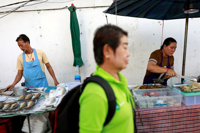 &copy; Reuters. FILE PHOTO: A person walks pass some vendors on the street at a market in Bangkok, Thailand, September 26, 2019. REUTERS/Soe Zeya Tun/File Photo