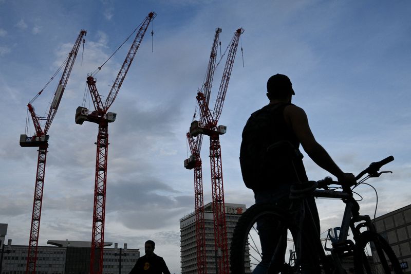&copy; Reuters. FILE PHOTO: A man pushes his bicycle near a construction site with cranes at Alexanderplatz in Berlin, Germany October 2, 2023. REUTERS/Annegret Hilse/File Photo