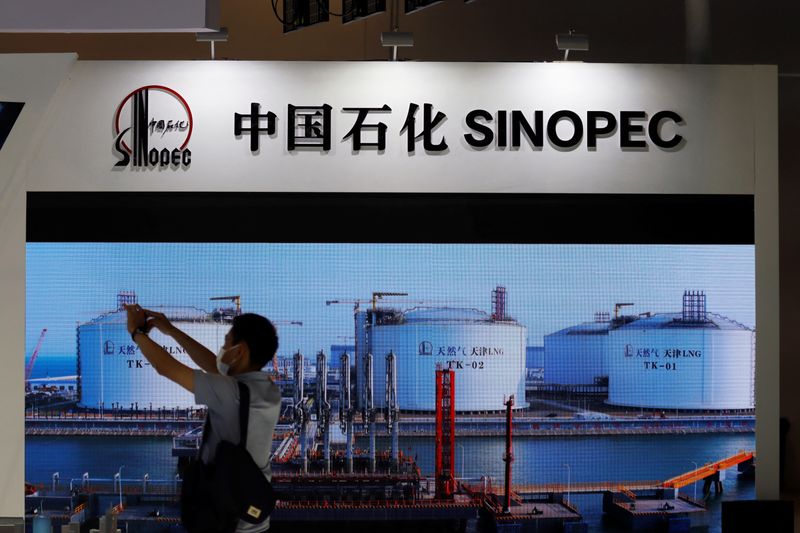 &copy; Reuters. رجل يلتقط صورا بالقرب من شاشة تعرض منظرا لمحطة للغاز الطبيعي المسال تابعة لشركة الصين للبترول والبتروكيماويات (سينوبك) في معرض الصين الدولي