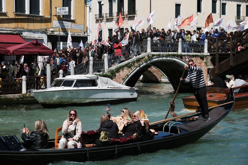 © Reuters. People protest against the introduction of the registration and tourist fee to visit the city of Venice for day trippers introduced by Venice municipality in a move to preserve the lagoon city often crammed with tourists in Venice, Italy, April 25, 2024. REUTERS/Manuel Silvestri