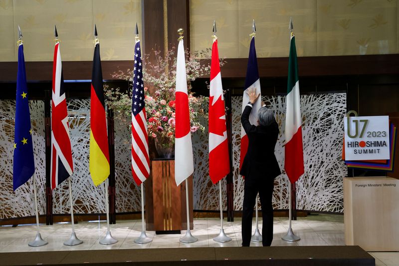 &copy; Reuters. Un funzionario sistema le bandiere prima che i ministri degli Esteri del G7 si riuniscano durante gli incontri a Tokyo, in Giappone, 8 novembre 2023. REUTERS/Jonathan Ernst/Pool/File Photo