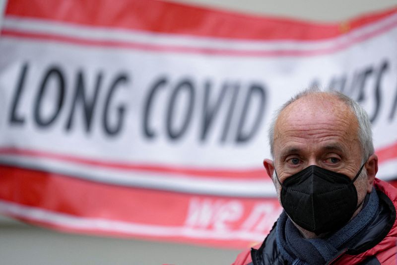 &copy; Reuters. FILE PHOTO: A man looks on as family members of people who died during the coronavirus disease (COVID-19) pandemic hold banners as they wait outside the UK COVID-19 inquiry, where the former British Prime Minister Boris Johnson is giving evidence, in Lond