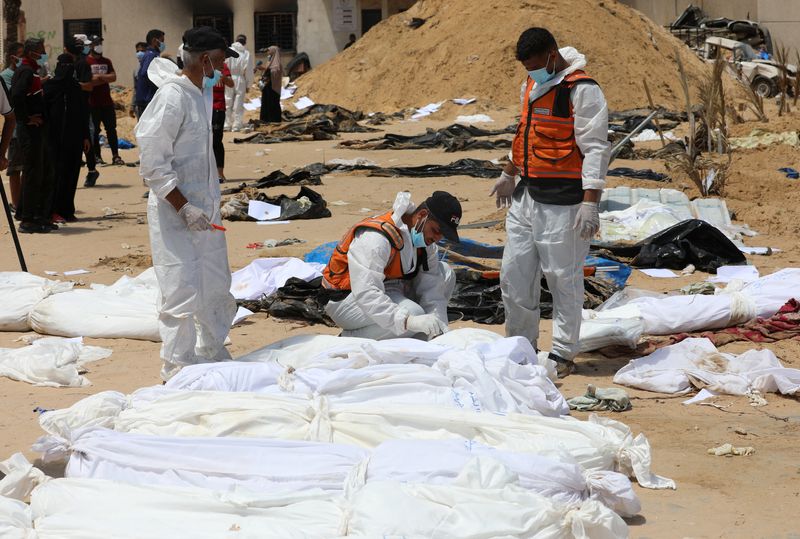 &copy; Reuters. أشخاص يعملون على نقل جثث فلسطينيين قتلوا خلال الهجوم العسكري الإسرائيلي ودفنوا بمستشفى ناصر في خان يونس بجنوب قطاع غزة يوم 21 أبريل نيسان 2024.